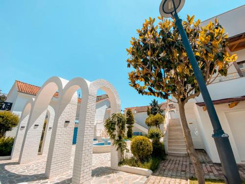 ein Baum vor einem Gebäude mit Straßenbeleuchtung in der Unterkunft Diamma Resort Conference & Spa in Durrës