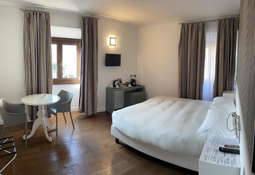 una camera d'albergo con letto, tavolo e scrivania di Il Vecchio Borgo Relais a Como