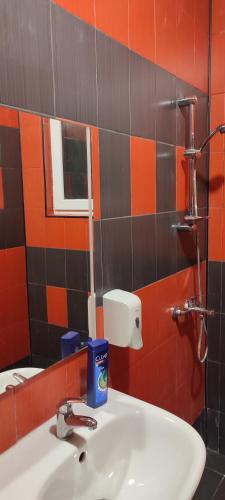 a bathroom with a sink and orange and black tiles at Ivka in Gabrovo