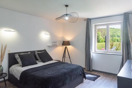 1 dormitorio con cama y ventana en Maison de vacances avec piscine en Montignac