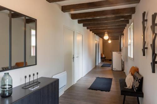 un pasillo con paredes blancas y techos de madera en Maison de vacances avec piscine en Montignac