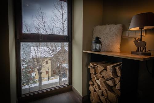 een kamer met een raam met uitzicht op een met sneeuw bedekte tuin bij Apartament el Cabirol in La Molina