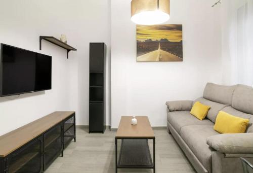 a living room with a couch and a flat screen tv at Fantastic apartment in the heart of Alicante in Alicante