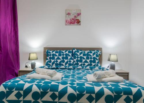 1 cama azul y blanca con 2 almohadas en Cozy Apartment Close to the SEA 4 en St. Paul's Bay