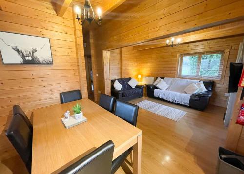 uma sala de estar com uma mesa e um sofá em Oathill Farm Lodges em Winsham