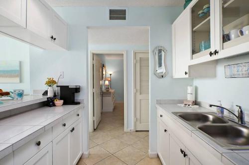 eine Küche mit weißen Schränken und einem Waschbecken in der Unterkunft Beachfront Sunrise  in Galveston
