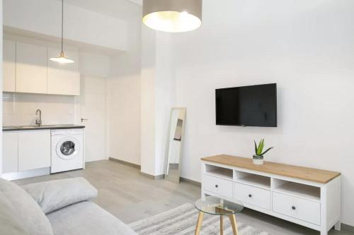 uma sala de estar com um sofá e uma televisão na parede em Very nice and modern flat, in Alicante Center em Alicante