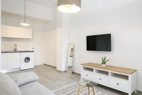 ein Wohnzimmer mit einem Sofa und einem Fernseher an der Wand in der Unterkunft Very nice and modern flat, in Alicante Center in Alicante