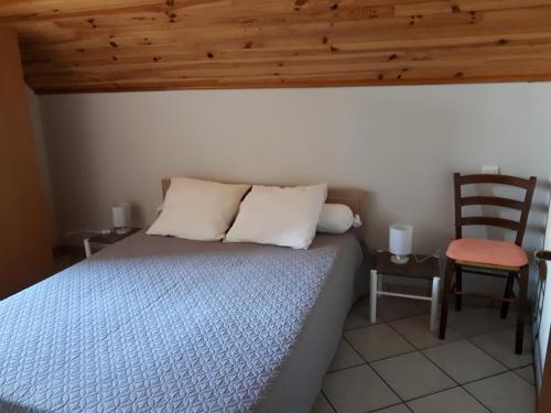 - une chambre avec un lit, un plafond en bois et une chaise dans l'établissement LA TRUFFIERE, à Castelnau-de-Mandailles