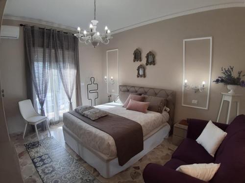 a bedroom with a large bed and a couch at Il moro di Sicilia apartment in Termini Imerese