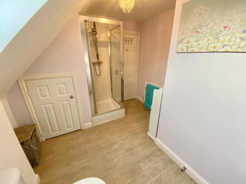 uma casa de banho no sótão com um chuveiro e um espelho. em Number 2, Spacious Rooms, Near Ironbridge! em Telford