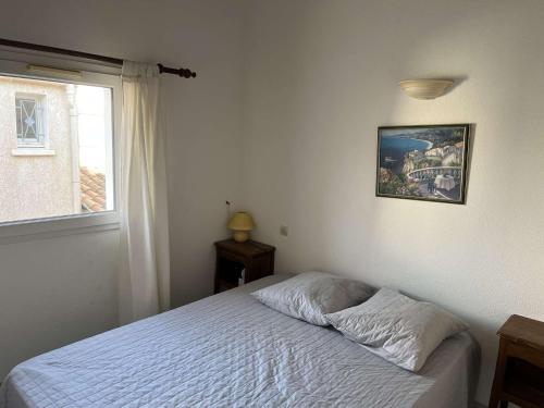 une chambre avec un lit blanc avec une fenêtre dans l'établissement Maison de vacances climatisée avec terrasse, parking privé, proche plage et commerces - FR-1-387-190, à Marseillan