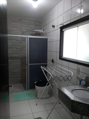 a bathroom with a shower and a sink and a window at Apartamento de hospedagem-calendula in Joinville