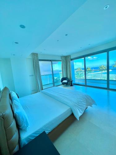 una camera da letto con un letto grande con vista sull'oceano di Aphrodite Plaza a Larnaka