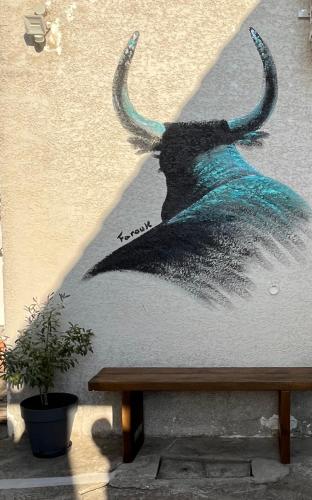 a wall with a painting of a bull with horns at L Abri-côtier Appartements in Saintes-Maries-de-la-Mer