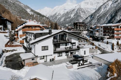 een huis in de sneeuw met bergen op de achtergrond bij Crystal Lake in Sölden