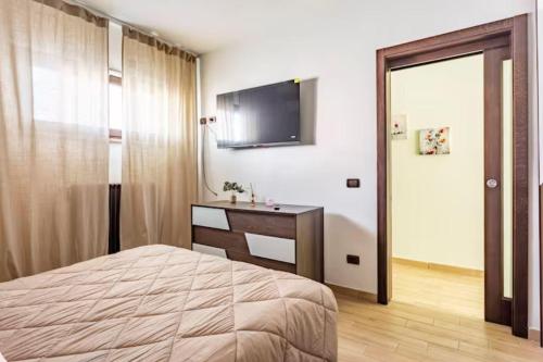 a bedroom with a bed and a television on the wall at Old Lighthouse - Beach Apartment - Fiumicino Airport in Fiumicino