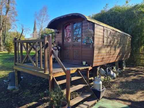 a wooden train car on display in a yard at Roulotte d'Aquitaine in Saint-Sulpice-de-Faleyrens