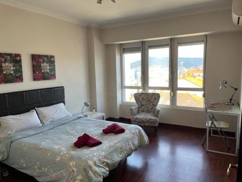 - une chambre avec un lit, une chaise et des fenêtres dans l'établissement Vigo Excursions, à Vigo