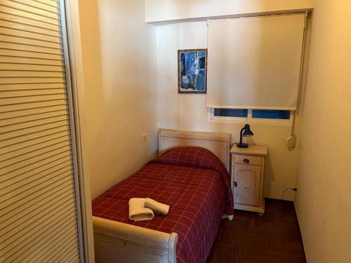 una piccola camera con un letto con una coperta rossa di Vigo Excursions a Vigo