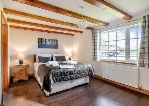 a bedroom with a bed and a large window at Hornsea Lakeside Lodges in Hornsea