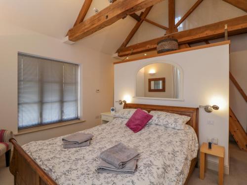 a bedroom with a bed and a large window at The Coach House in Tewkesbury