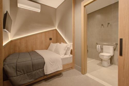 um pequeno quarto com uma cama e um WC em Fast Sleep Suites by Slaviero Hoteis - Hotel dentro do Aeroporto de Guarulhos - Terminal 2 - desembarque oeste em Guarulhos