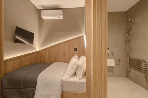 Dormitorio pequeño con cama y ducha en Fast Sleep Suites by Slaviero Hoteis - Hotel dentro do Aeroporto de Guarulhos - Terminal 2 - desembarque oeste en Guarulhos