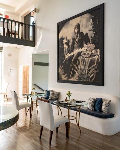 a living room with tables and a painting on the wall at Greco Hotel in Búzios