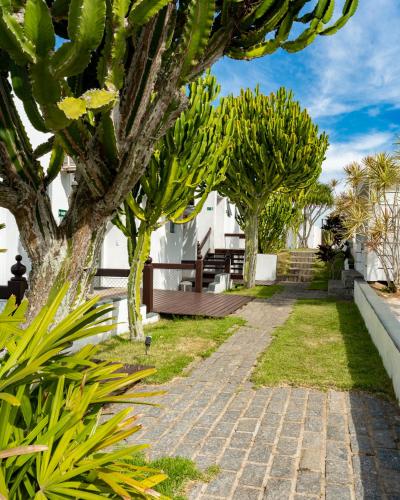 a garden with trees and a brick path at Greco Hotel in Búzios