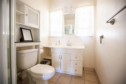 uma casa de banho com um WC, um lavatório e um espelho. em Spacious 2 Bedroom unit With Fireplace F em Los Angeles