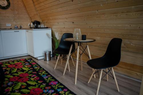 een keuken met een tafel en 2 stoelen en een koelkast bij Casuta Mea in Piatra Neamţ