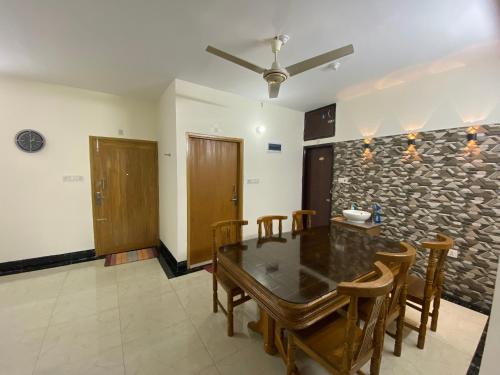 ein Esszimmer mit einem Tisch, Stühlen und einer Steinmauer in der Unterkunft 3 beds flat in Chittagong in Chittagong