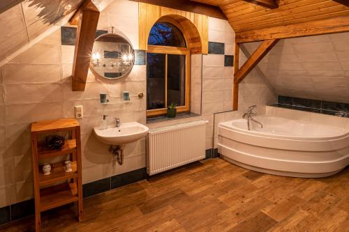 ein großes Bad mit einer Badewanne und einem Waschbecken in der Unterkunft Villa Landidyll mit separatem Wellness-Bereich in Joachimsthal