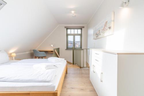 a bedroom with two beds and a desk at Ferienhaussiedlung Strandperlen Buchenhof 2d (Typ I) in Wustrow