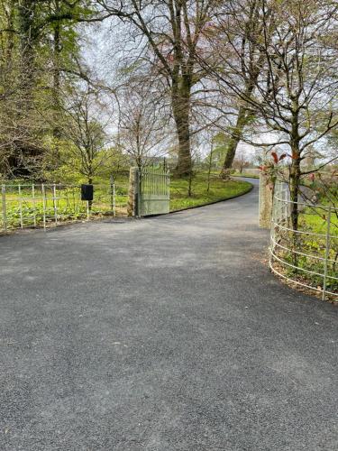 a driveway with a gate and a fence at Woodstock Courtyard in Inistioge