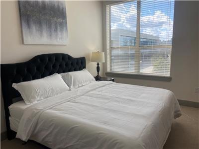 a large white bed in a bedroom with a window at Resort Style Apartments in Spring, TX in Spring
