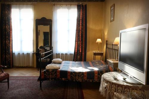 a living room with a flat screen tv and a bed at Austeria Klezmer Hois in Krakow