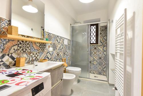 a bathroom with a shower and a toilet and a sink at Home Holiday Casanica in Agrigento