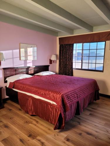 1 dormitorio con 1 cama grande y ventana grande en Espana Motel en Norwalk