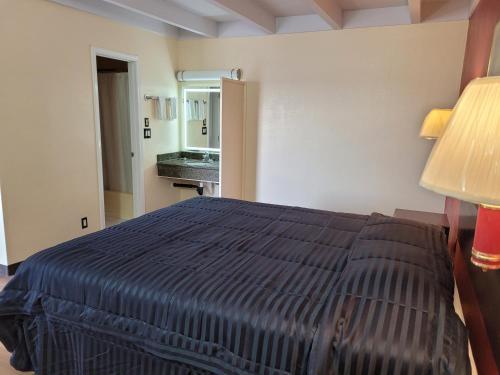a hotel room with a bed and a bathroom at Espana Motel in Norwalk