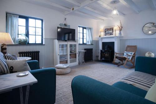 a living room with a blue couch and a fireplace at The Old Spa - 2 Bedroom Cottage - Pleasant Valley in Stepaside
