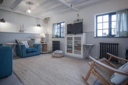 a living room with a blue couch and a tv at The Old Spa - 2 Bedroom Cottage - Pleasant Valley in Stepaside