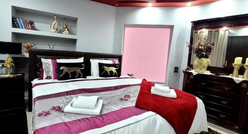 um quarto com uma cama grande e um cobertor vermelho e branco em Classic House Hotel em Korçë