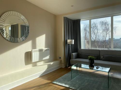 a living room with a couch and a mirror at AA Newcastle in Newcastle upon Tyne