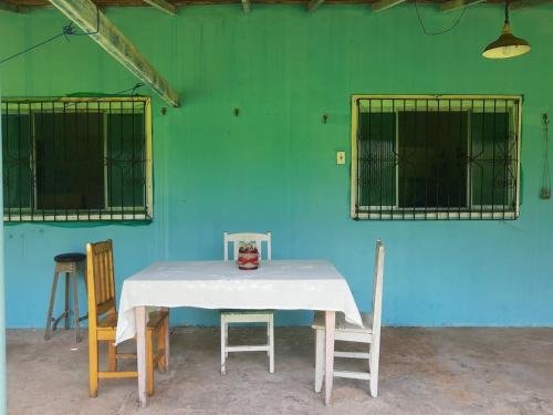 a table with a white table cloth and two chairs at Sítio Família Morais in Salvaterra