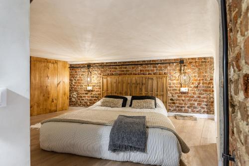ein Schlafzimmer mit einem Bett und einer Ziegelwand in der Unterkunft BNBHolder Delightful CENTRE in Madrid