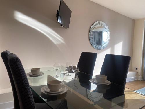 a glass table with black chairs and a mirror at AA Newcastle in Newcastle upon Tyne