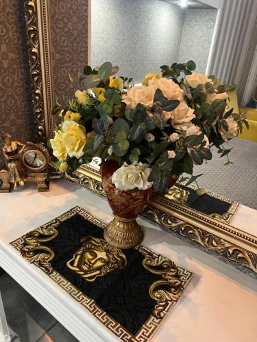 a vase with flowers on a table in front of a mirror at Apartments Lux in city center Lviv in Lviv