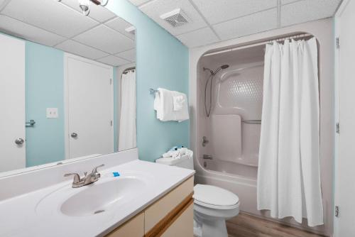 uma casa de banho com um lavatório, um WC e um espelho. em Edgewater Golf Villa 2110 em Panama City Beach